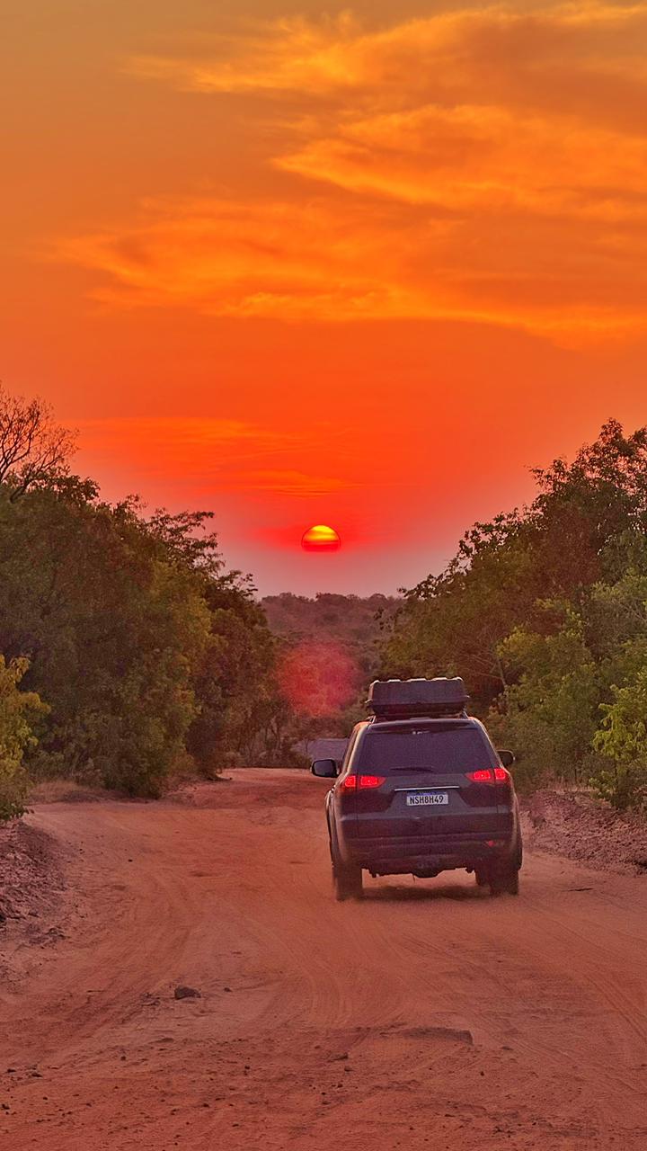 Veículo 4x4 em estrada de terra ao pôr do sol